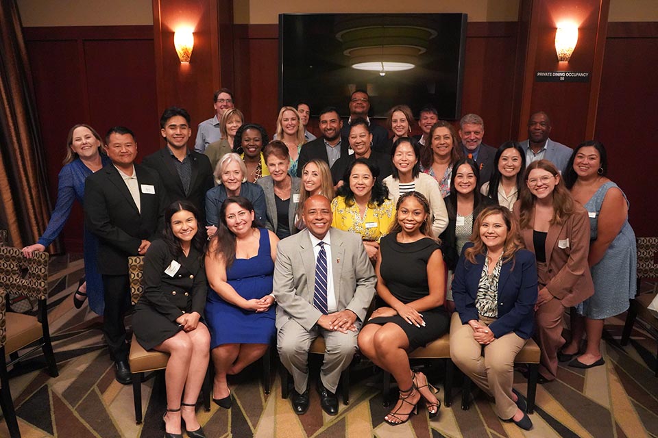 President Rochon posing with a large gathering of attendees of the event.