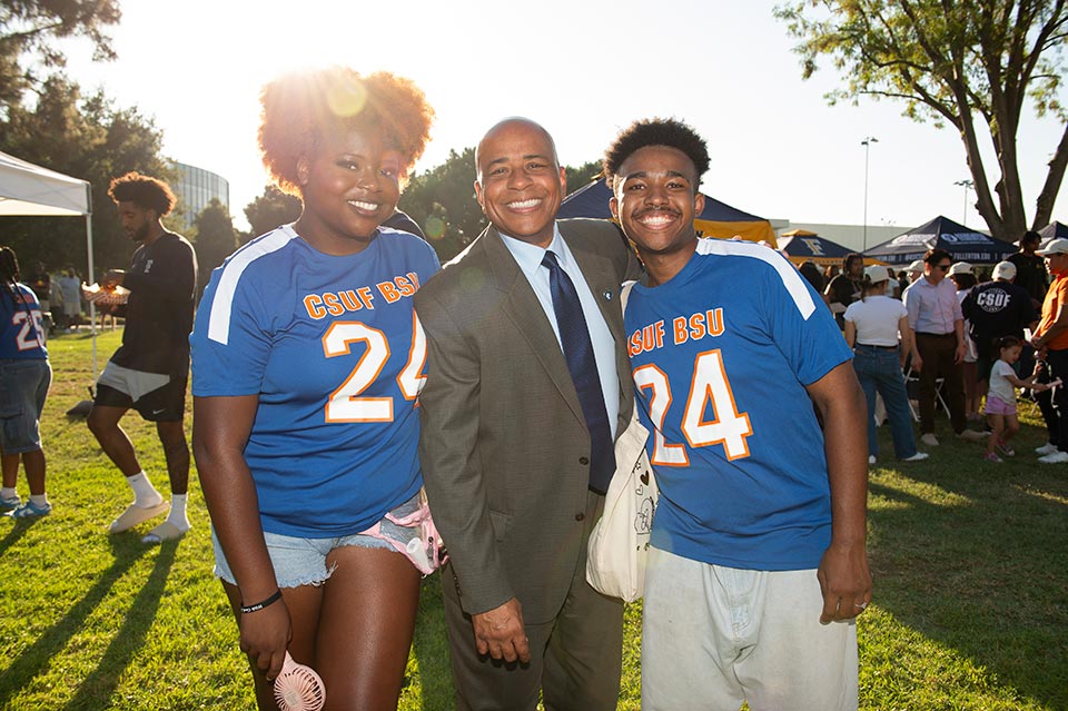 President Rochon posing with two students attending the event