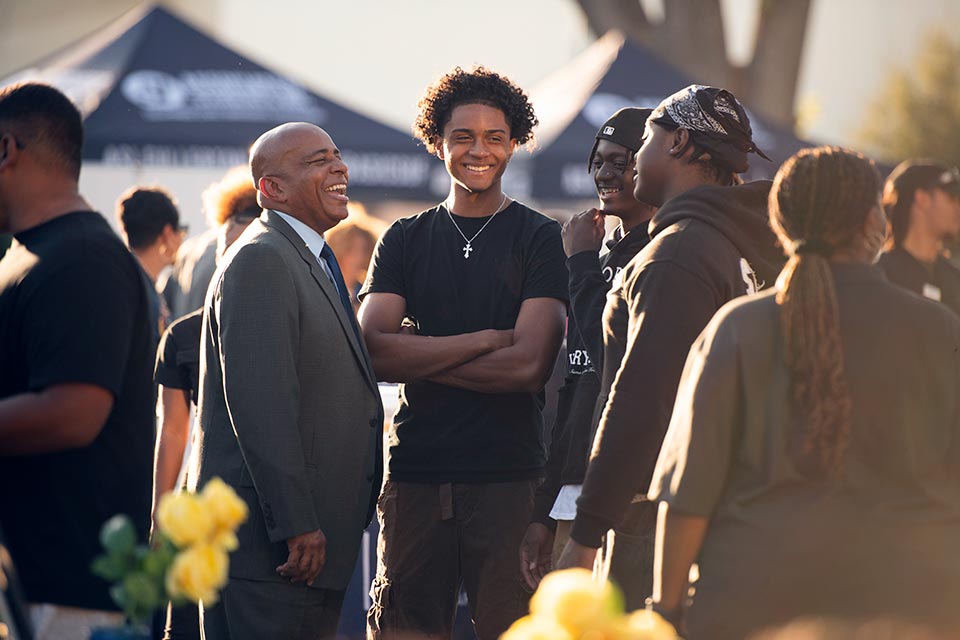 President Rochon conversing with a group of male students.