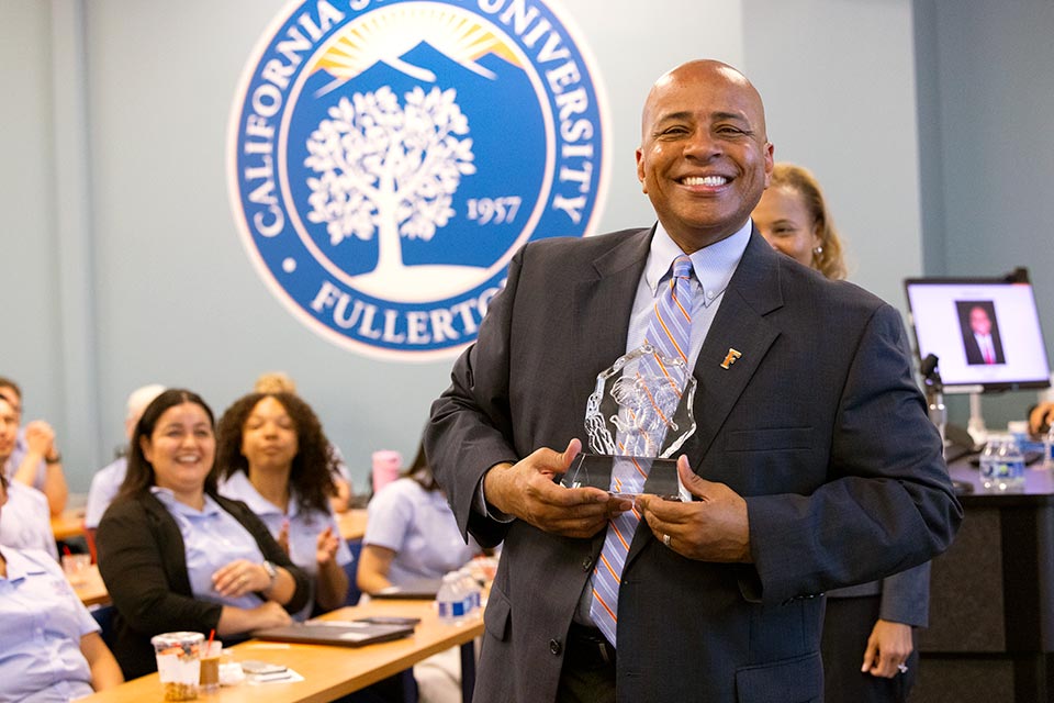 President Rochon proudly holding a trophy.