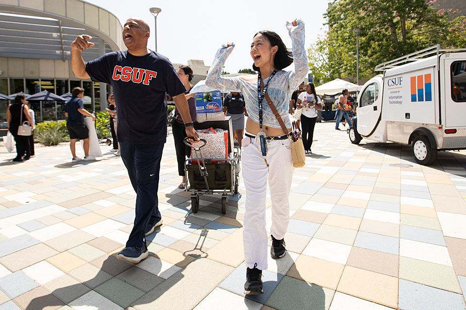 President Rochon cheering with a student while walking towards student housing