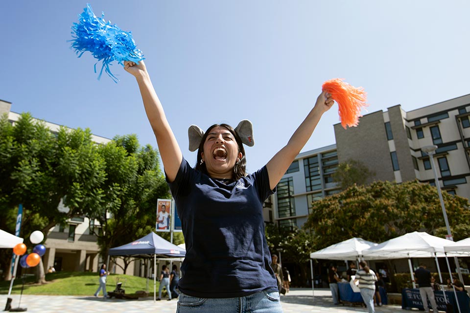 Student with pompoms cheering