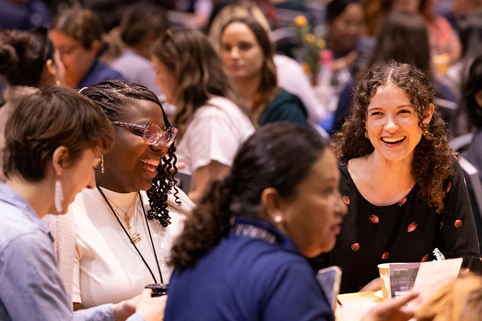 Group of seated Student Affairs employees laughing