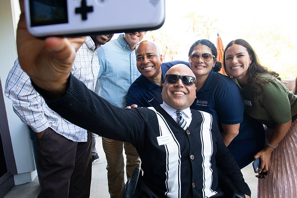 President Rochon taking a selfie with a group of employees.