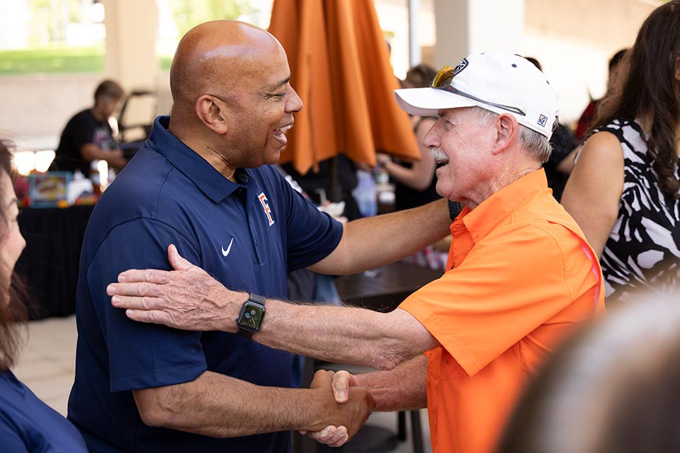 President Rochon shaking hands with an attendee.