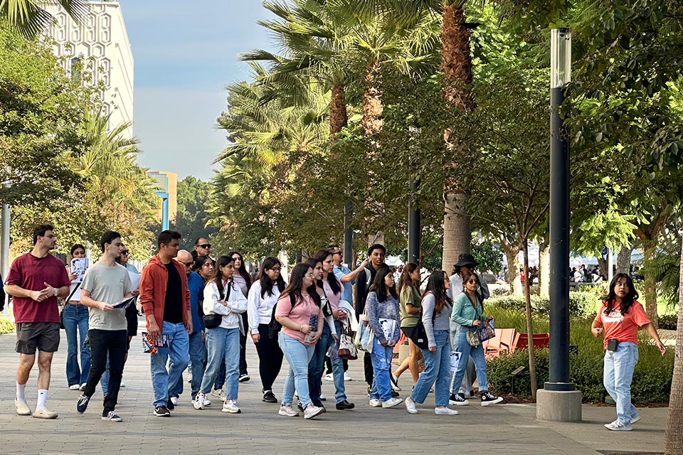 A tour guide leads a group of attendees across campus